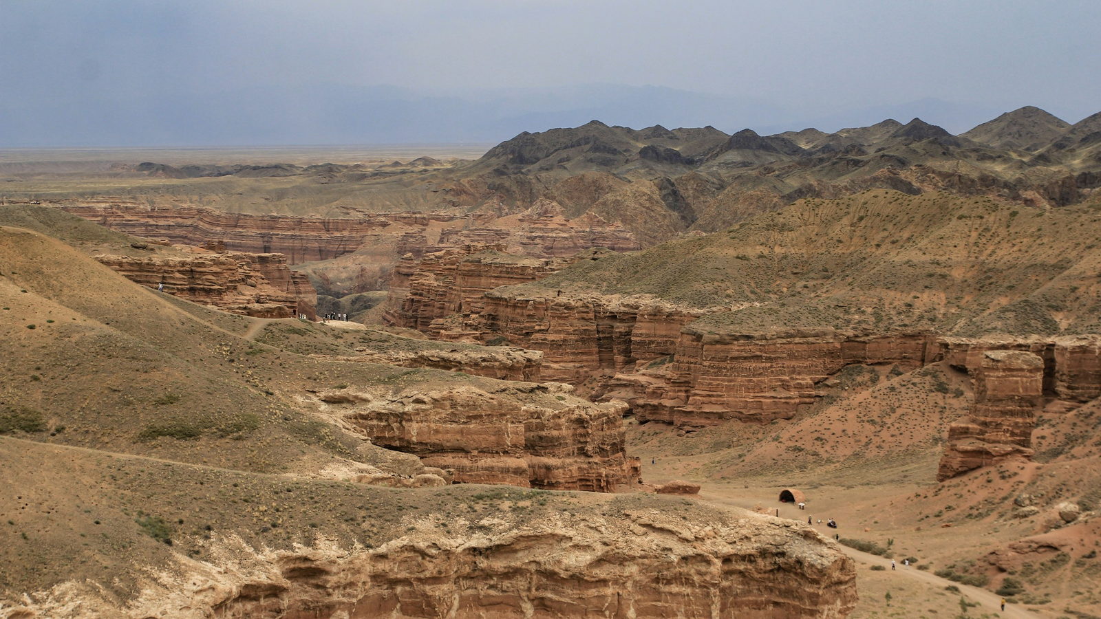 The layered red sandstone walls of Charyn Canyon stretching across the landscape